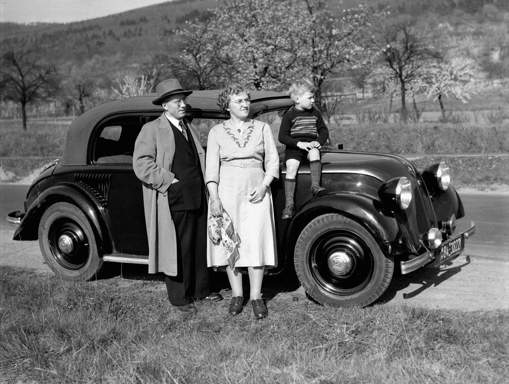 Detail of Father and mother stand with their son sitting on the hood of their Mercedes automobile, ca. 1950 by Anonymous