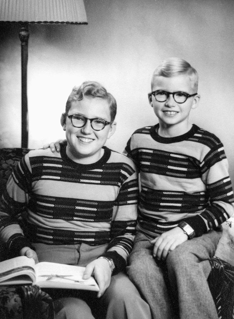 Detail of Two brothers pose with a book on their living room couch, ca. 1953 by Anonymous