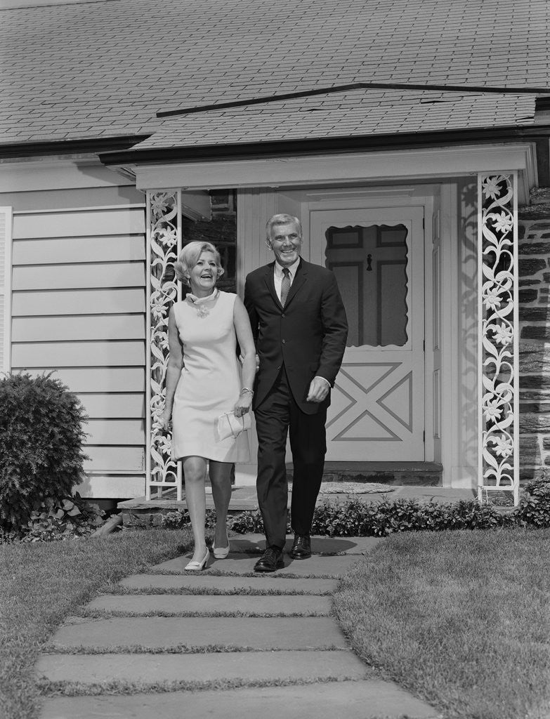 Detail of Mature couple walking on sidewalk front of house by Anonymous