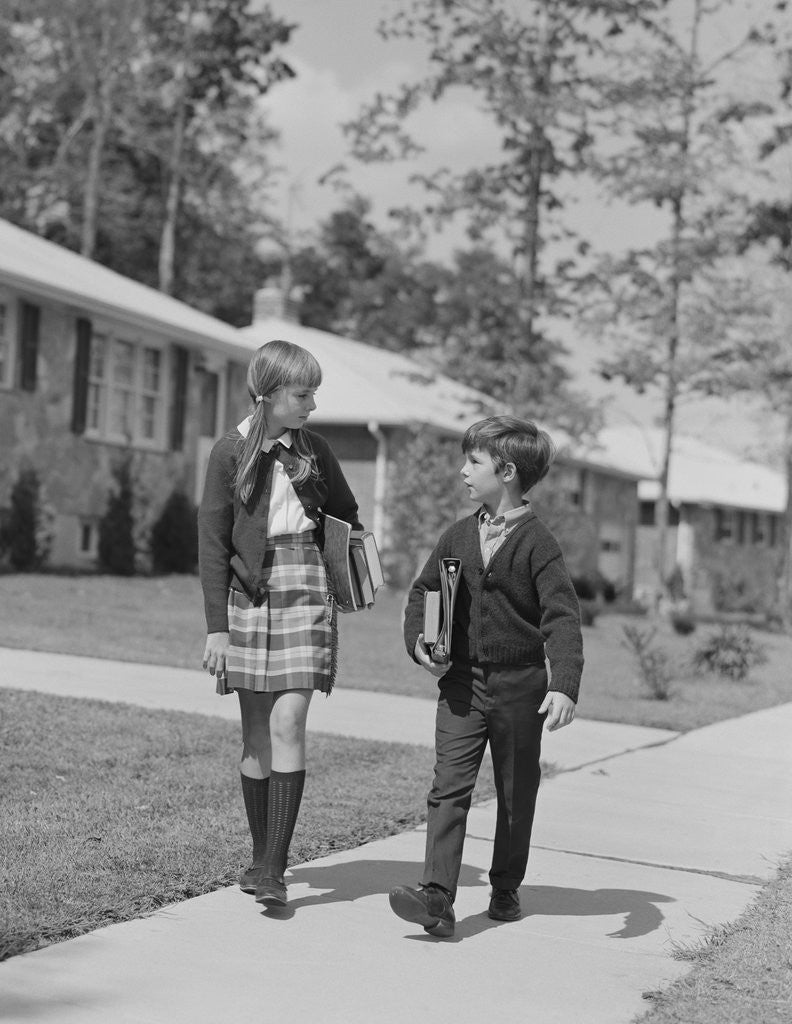 Detail of Boy girl carrying books walking to school in suburban neighborhood by Anonymous