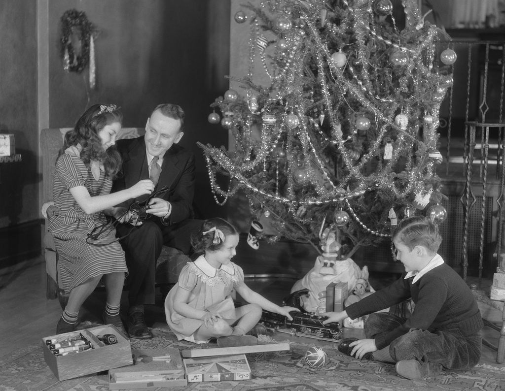 Detail of Family christmas photo father two daughters and son with presents and tree by Anonymous