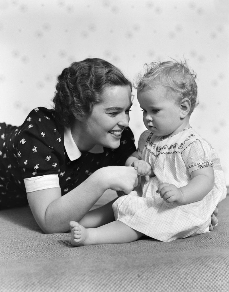 Detail of Woman mother smiling sitting playing with baby daughter by Anonymous