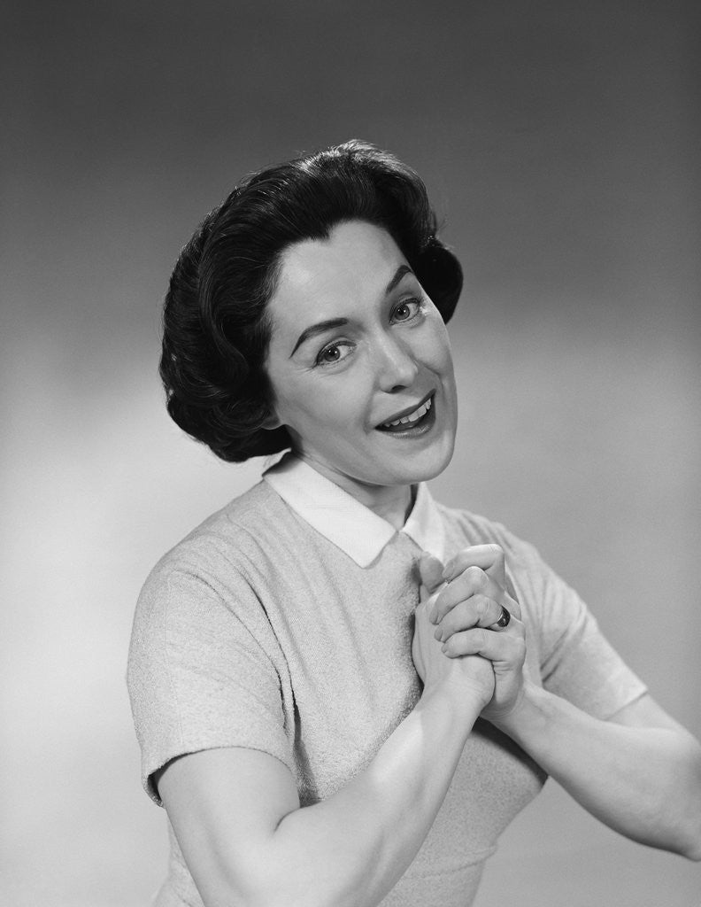 Detail of Brunette woman smiling happy satisfied proudly clasping hands to chest by Anonymous