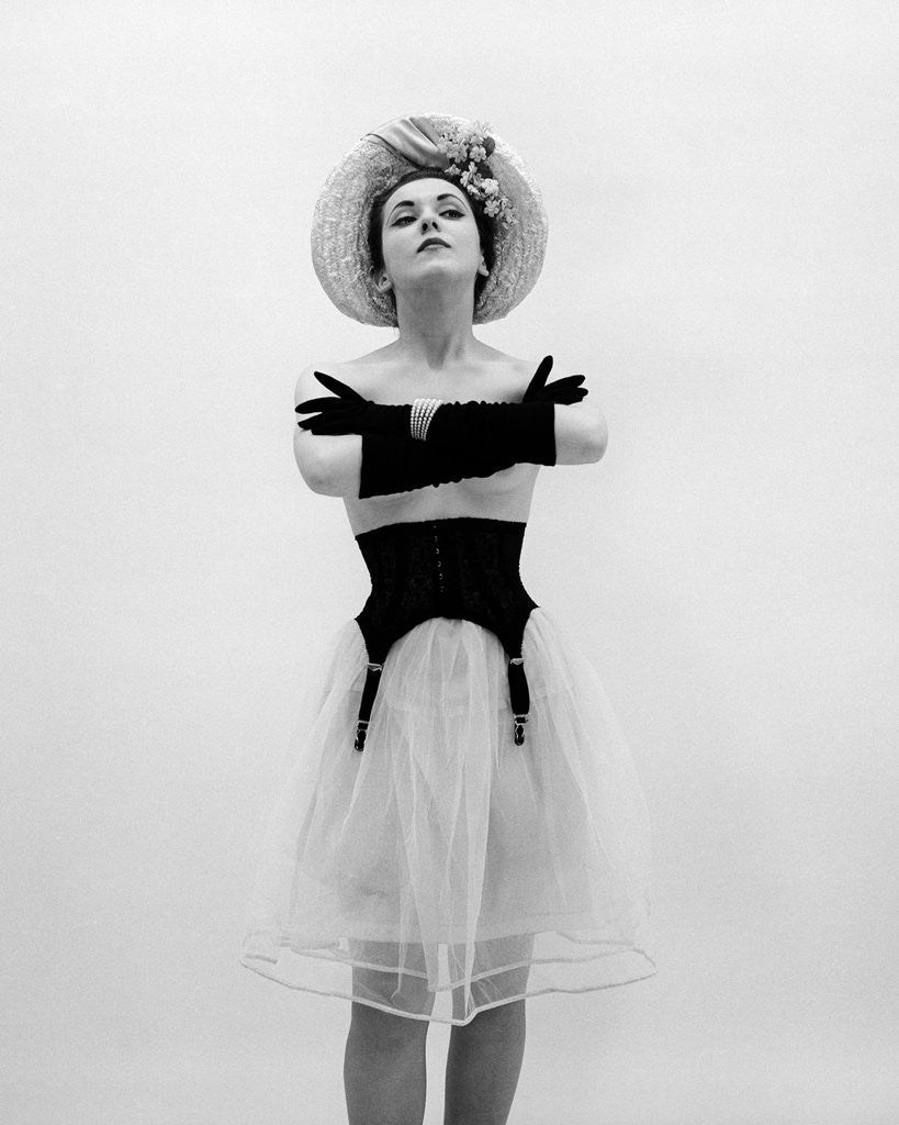 Detail of Woman topless wearing straw hat long gloves black garter belt arms folded in front by Anonymous