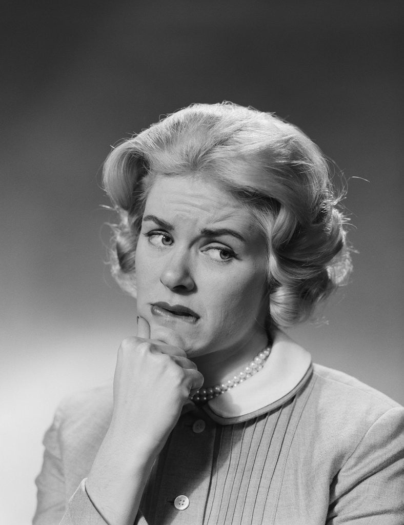 Detail of Blonde woman fist to chin worried serious facial expression by Anonymous