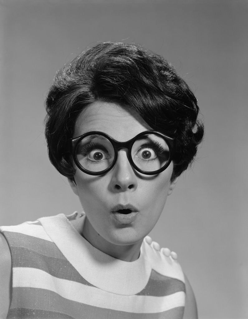 Detail of Portrait brunette wearing dark thick round eyeglasses with eyes wide open by Corbis