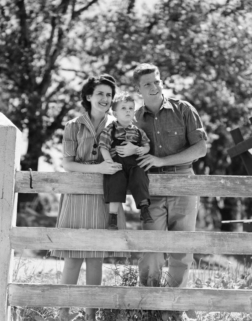 Detail of Smiling happy family mother father toddler boy portrait by farm fence by Anonymous