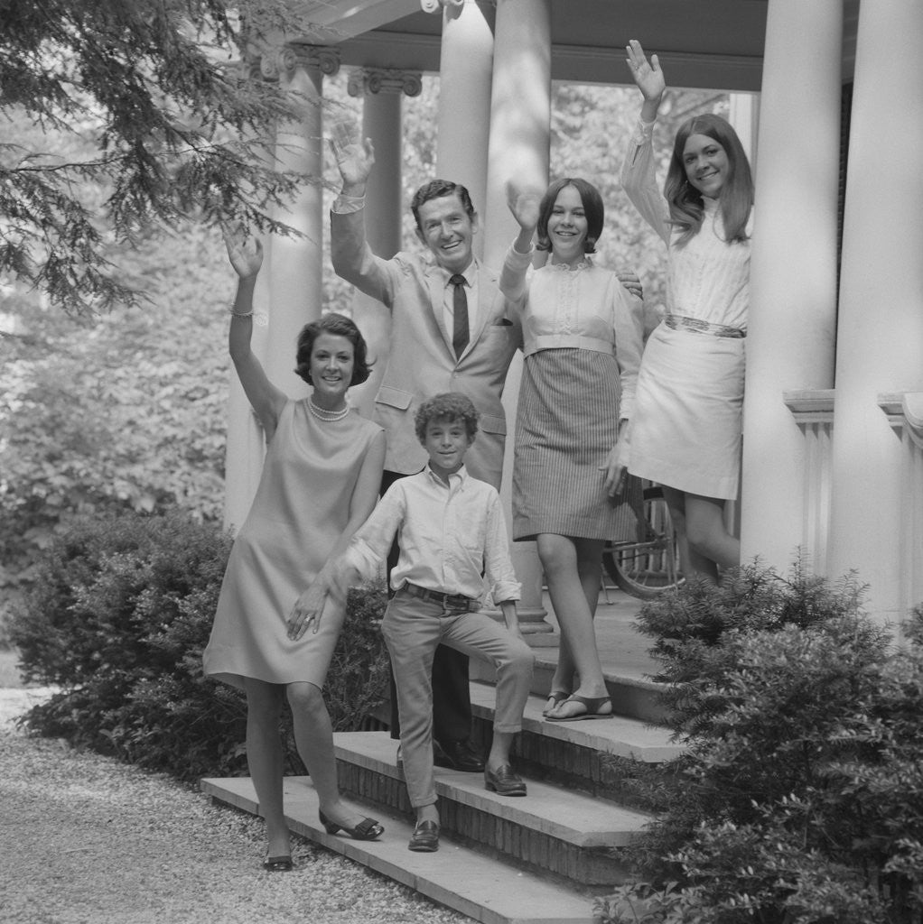 Detail of Family group of people standing on steps of house waving by Corbis