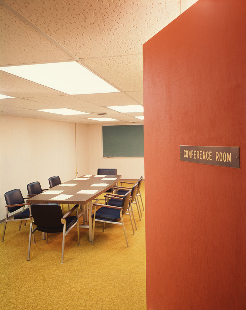 Detail of Conference room interior with table chairs chalkboard open door ajar by Corbis