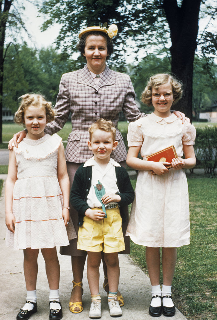 Detail of Mother and three children all dressed up posing for photo outdoors by Anonymous
