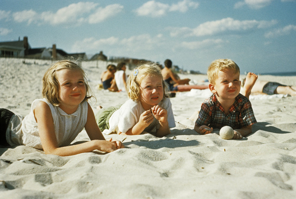Detail of 3 children lying on the beach at the jersey shore by Anonymous