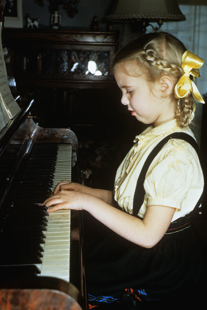 Detail of Little blond girl playing practicing the piano by Anonymous