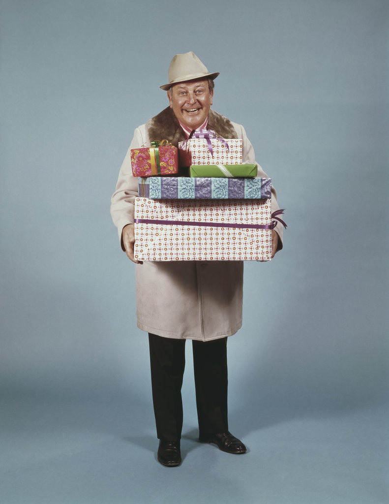 Detail of Smiling man hat coat carrying wrapped christmas presents by Anonymous