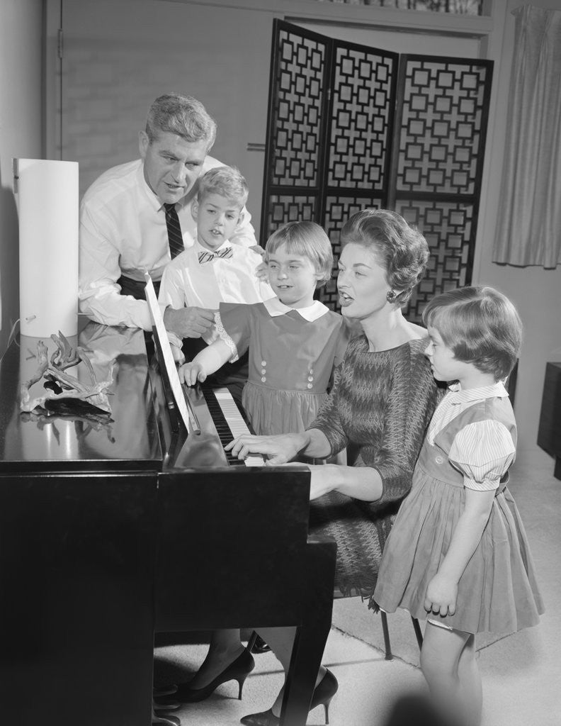 Detail of Family standing around piano singing by Anonymous