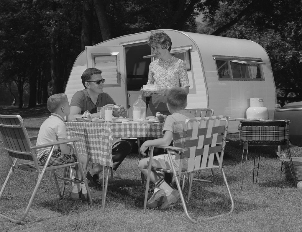 Detail of Family camping eating meal beside rv camper by Anonymous