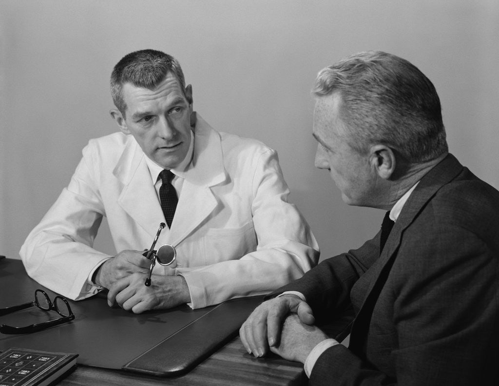 Detail of Doctor sitting at desk talking to male patient by Anonymous