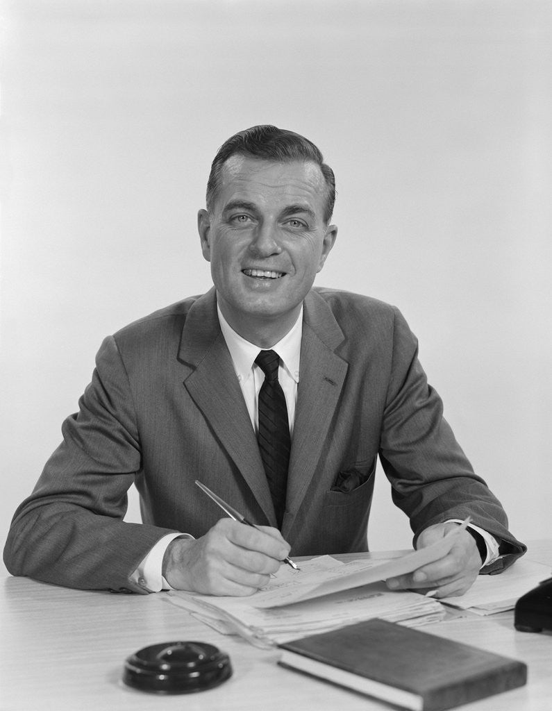 Detail of Smiling happy businessman pen in hand signing papers at desk by Anonymous