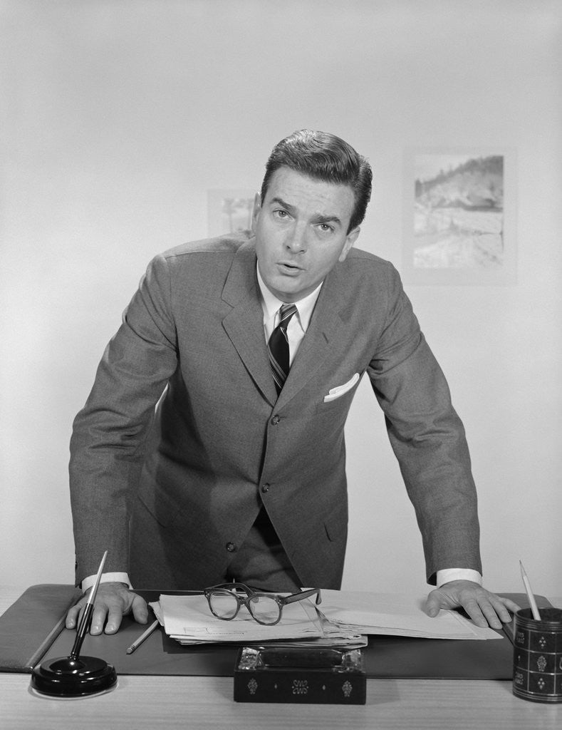 Detail of Businessman leaning over desk serious expression looking forward by Anonymous