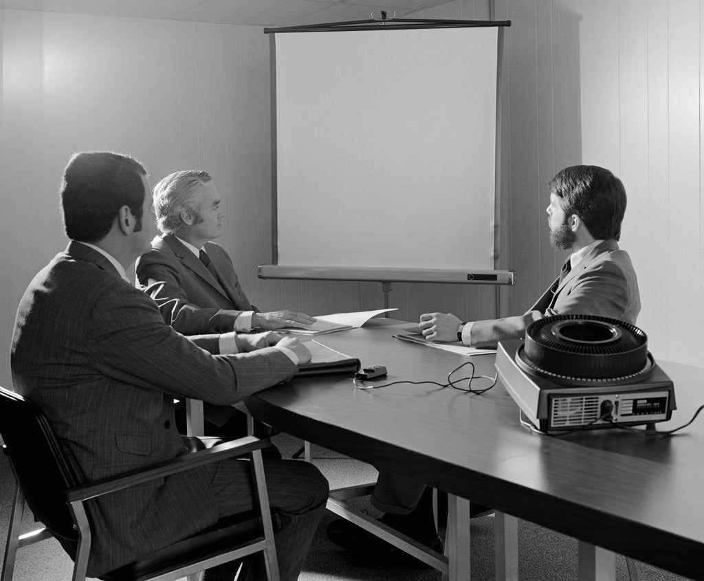 Detail of Three executive businessmen conference table audiovisual presentation by Anonymous