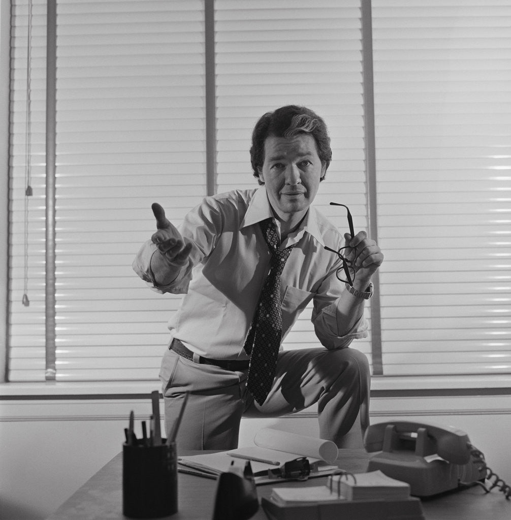 Detail of Businessman standing behind desk arm raised in pleading gesture by Anonymous