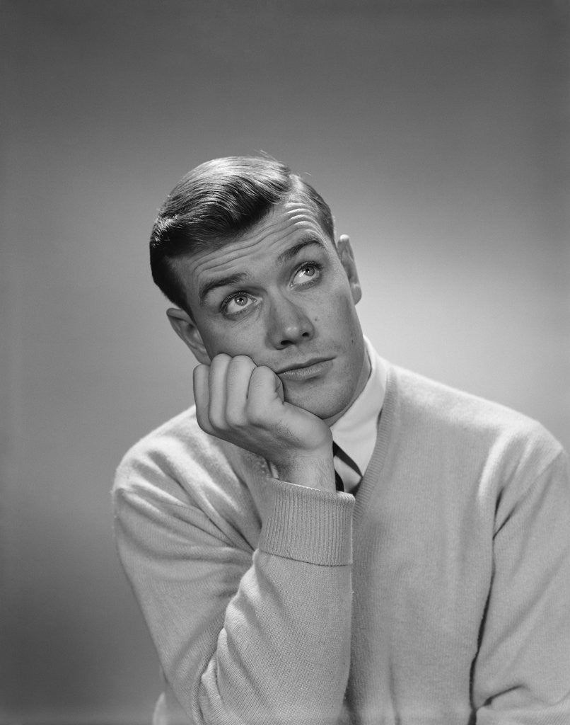 Detail of Young man hand to cheek looking up quizzical wondering thoughtful facial expression by Anonymous