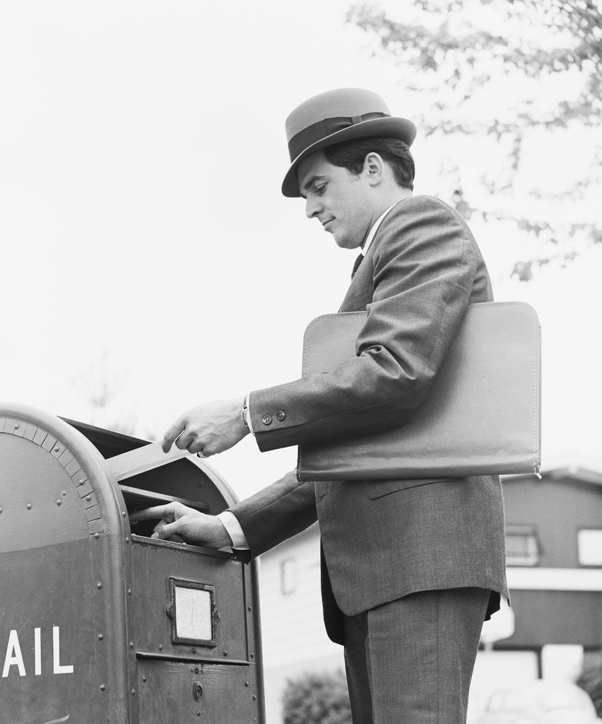 Detail of Young businessman with briefcase dropping letter into mailbox by Anonymous