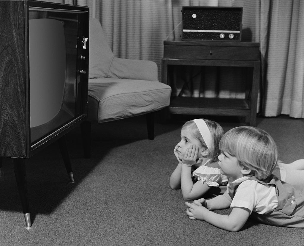 Detail of Two toddlers boy girl lying on floor watching television by Anonymous