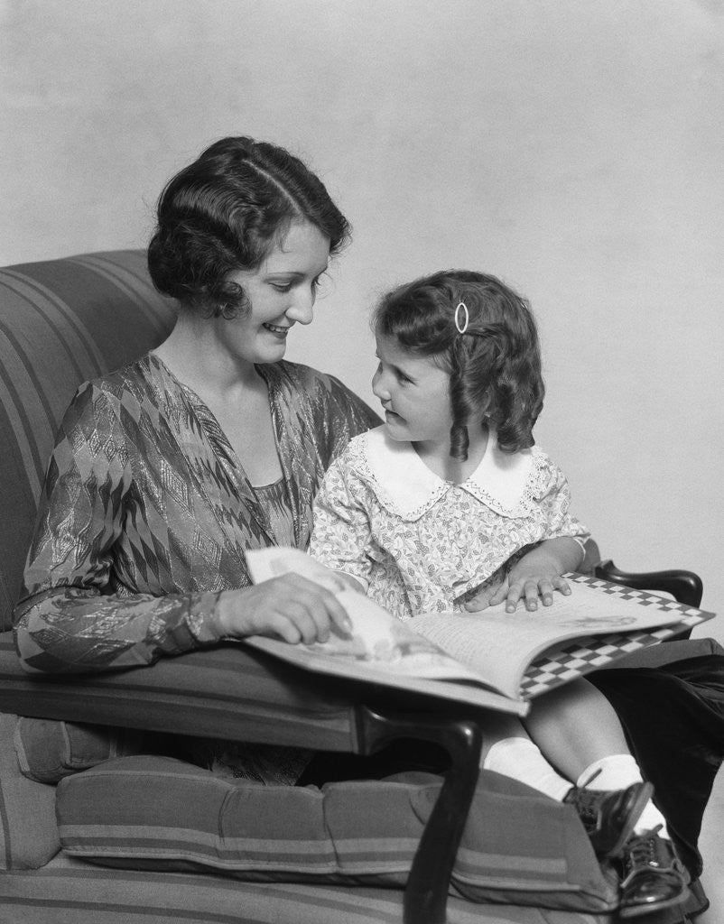 Detail of Mother & daughter smiling sitting in chair reading book by Anonymous
