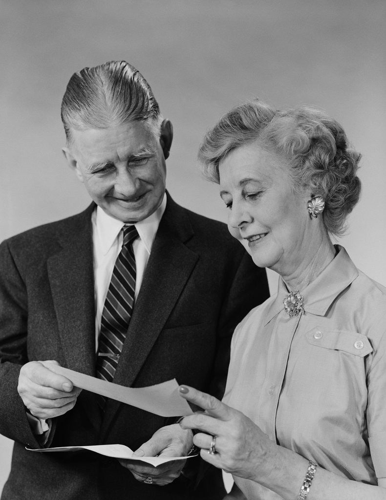Detail of Senior couple man woman reading holding check by Anonymous