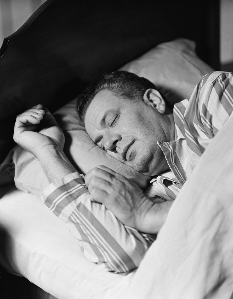 Detail of Man asleep sleeping in bed wearing pajamas by Anonymous