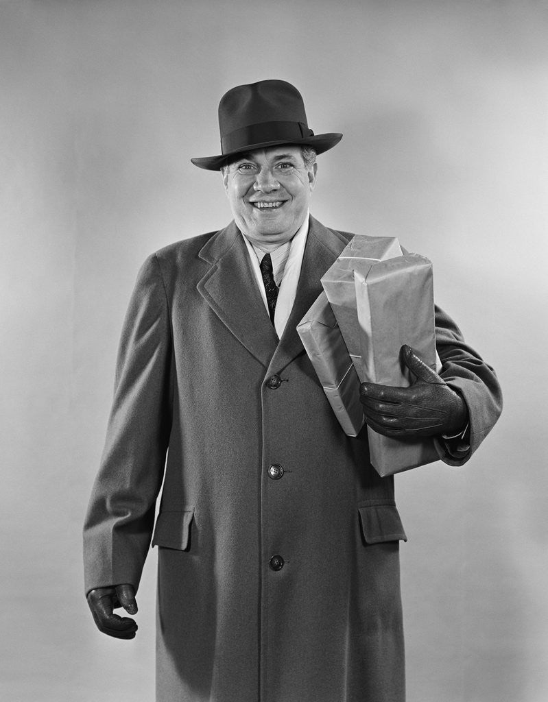 Detail of Smiling man carrying shopping boxes wearing hat coat gloves by Anonymous