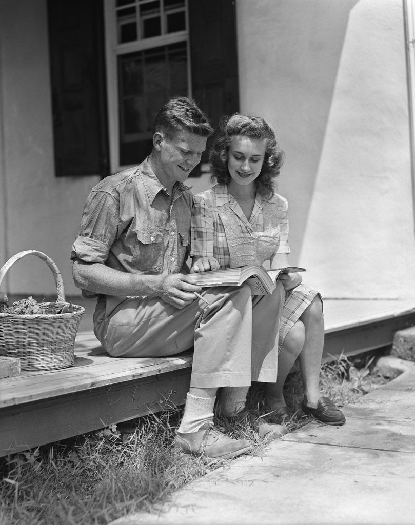 Detail of Man woman sitting on porch of farmhouse reading catalog by Anonymous
