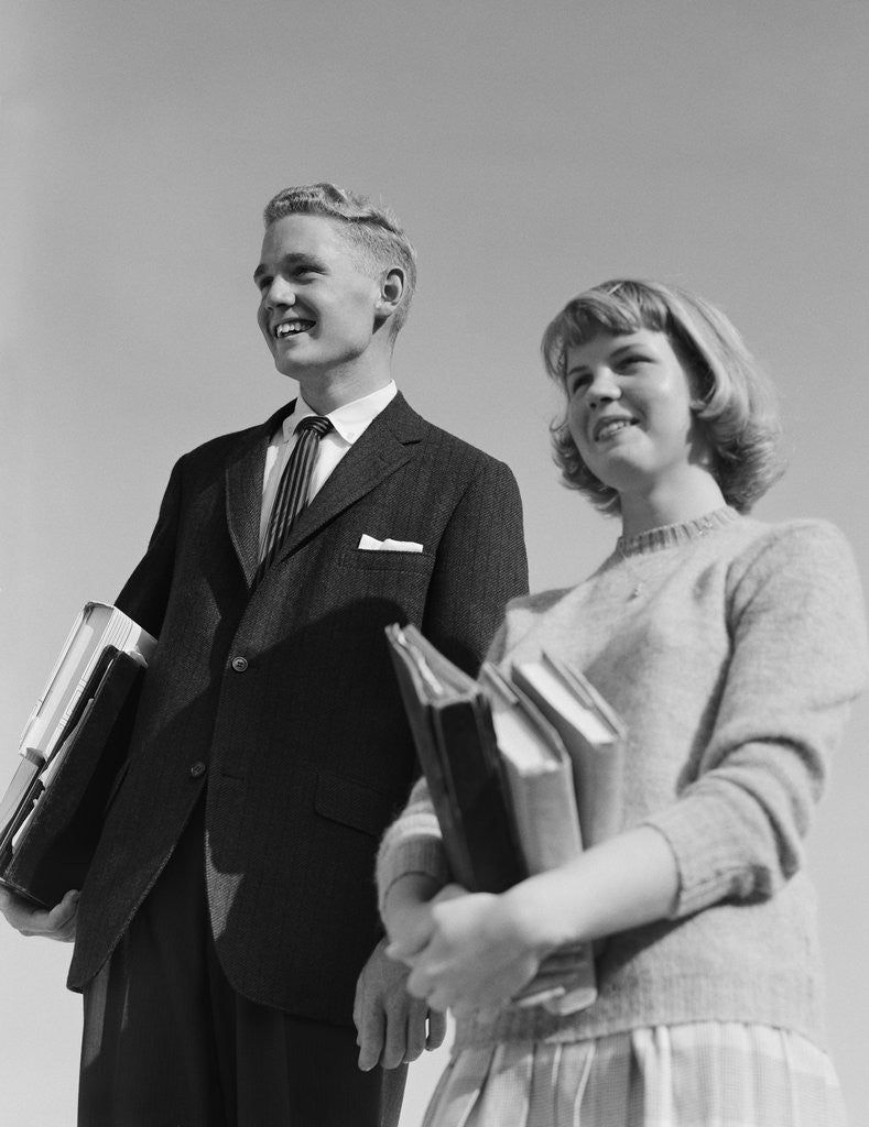 Detail of Portrait teenage boy girl holding school books by Corbis