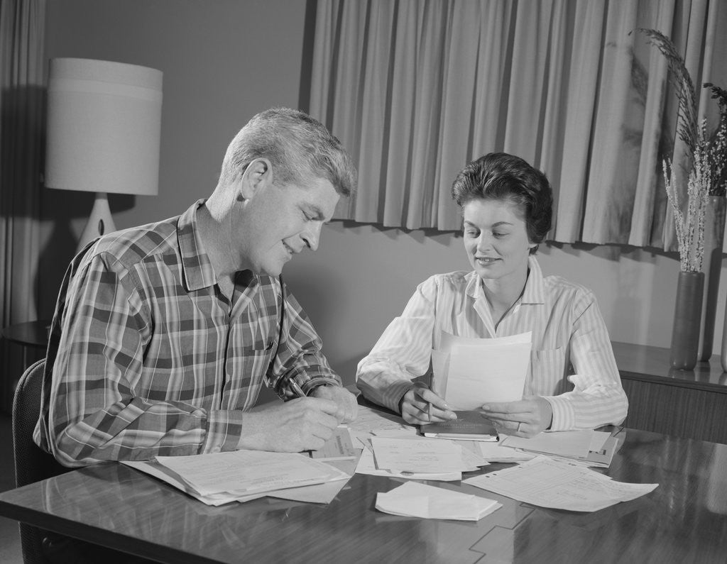 Detail of Couple man woman at table working on household accounts bills by Anonymous
