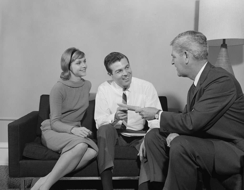 Detail of Couple sitting on couch talking to salesman by Anonymous
