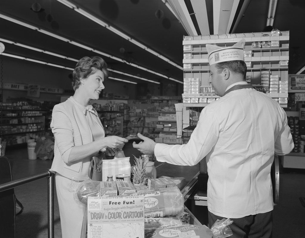 Detail of Woman paying at grocery store checkout male cashier by Anonymous