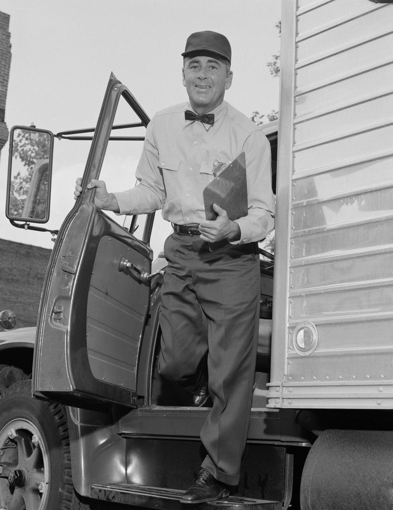 Detail of Delivery man stepping out of truck holding clipboard by Anonymous