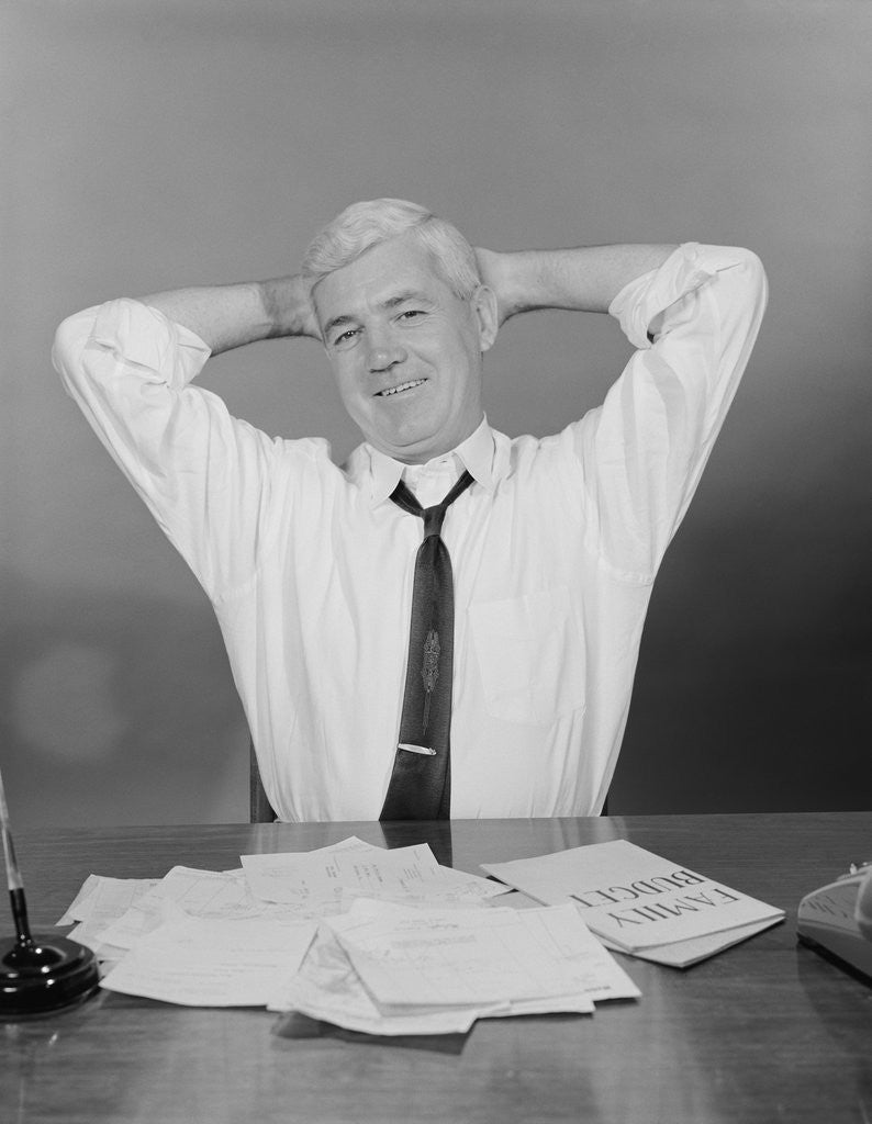 Detail of Smiling man working on family budget papers at desk by Anonymous