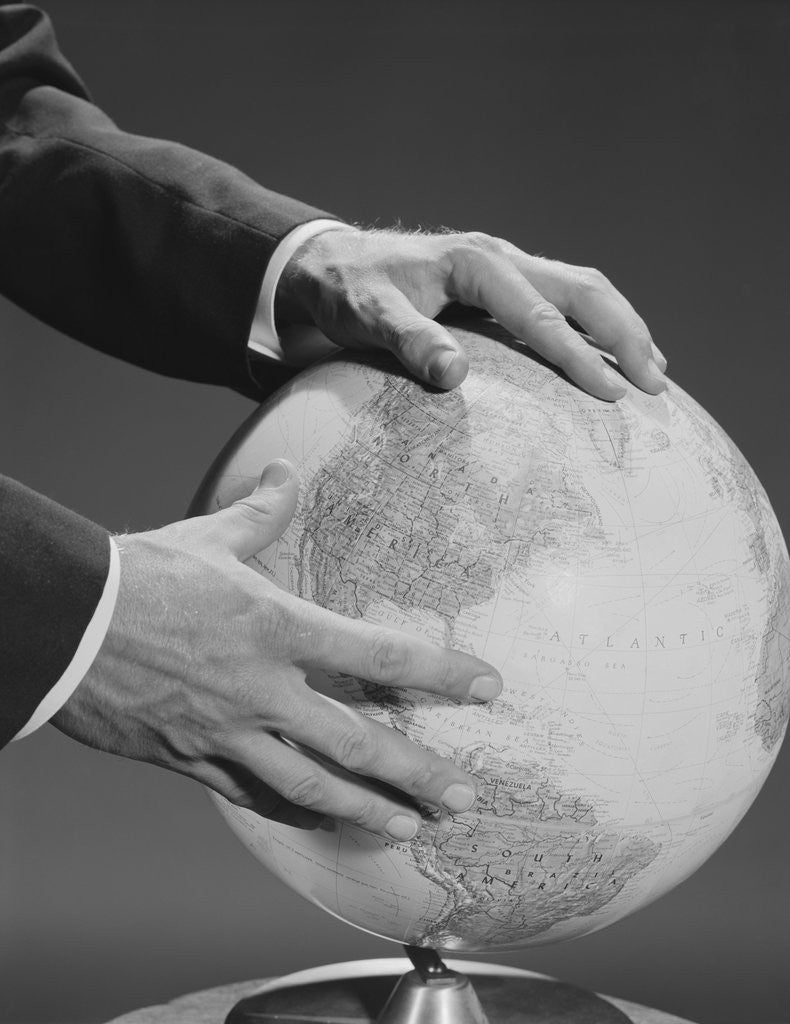Detail of Male hands holding earth globe by Corbis
