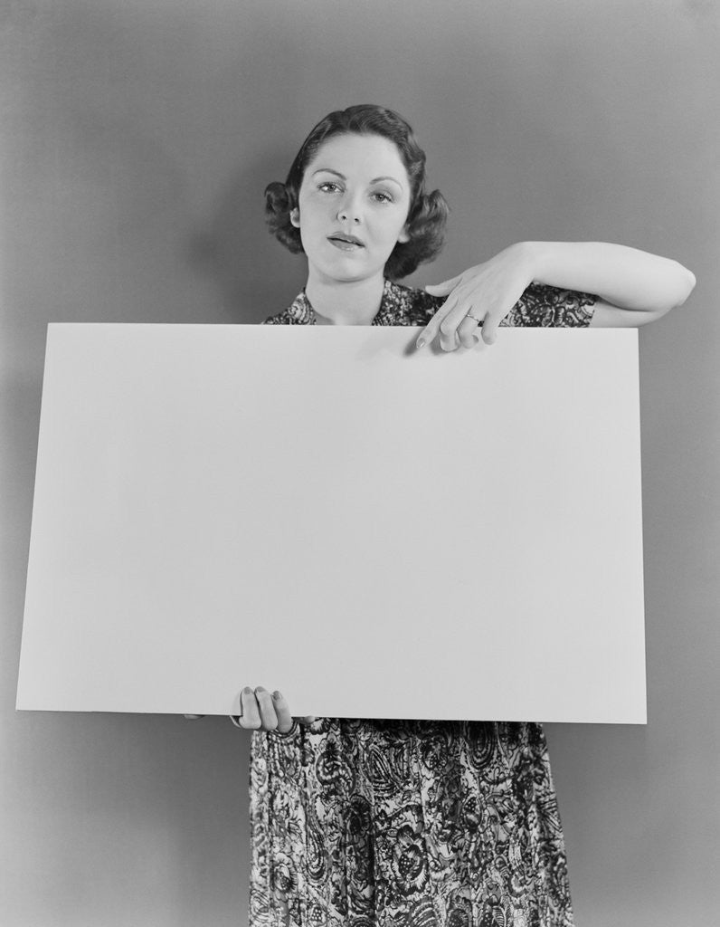 Detail of Woman holding blank poster sign hand pointing from top by Corbis