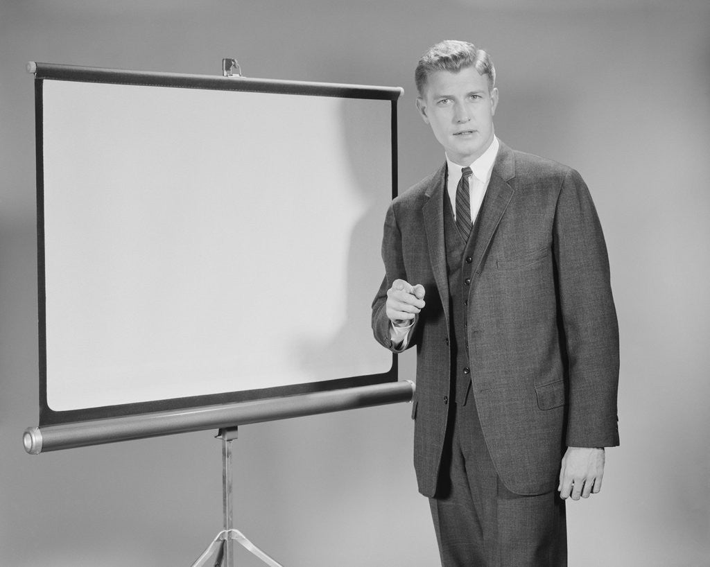 Detail of Man standing beside blank screen ready for presentation by Anonymous