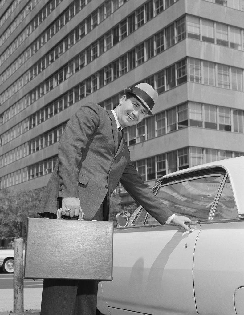 Detail of Businessman carrying briefcase getting into car on urban street by Anonymous