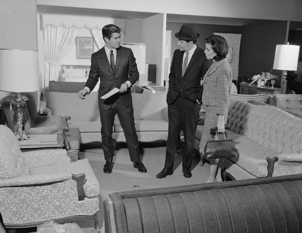 Detail of Furniture store salesman talking to couple by Anonymous