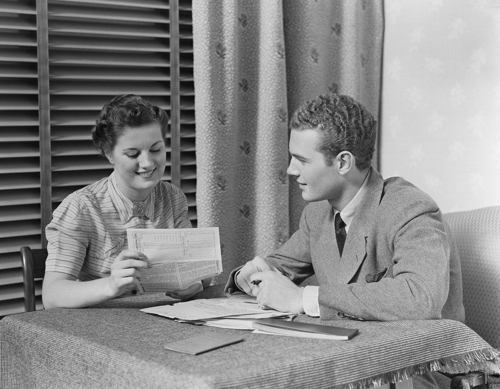 Detail of Couple man woman sitting at table going over papers by Anonymous