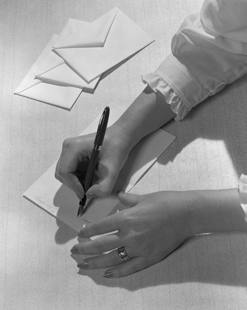 Detail of Woman's hands holding pen writing letter on stationery by Anonymous