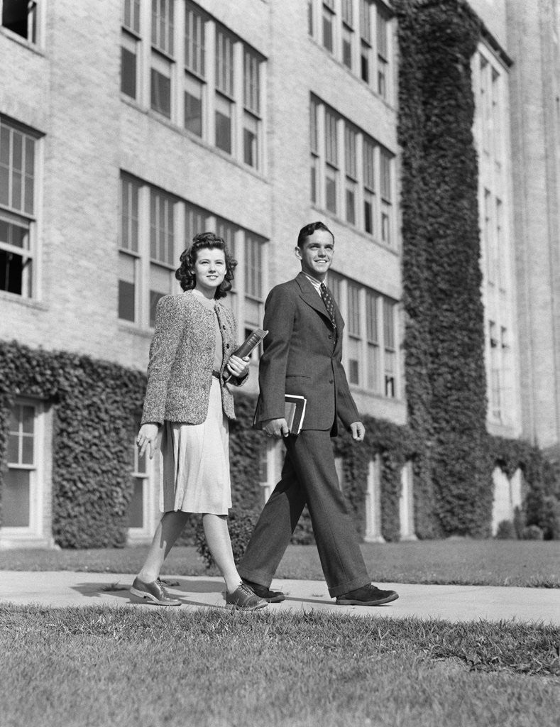 Detail of College couple walking on campus before ivy covered building by Anonymous