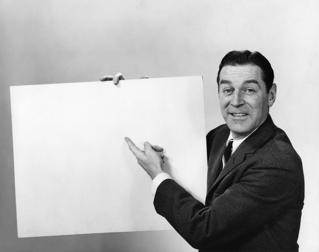 Detail of Smiling man pointing to blank poster sign by Corbis