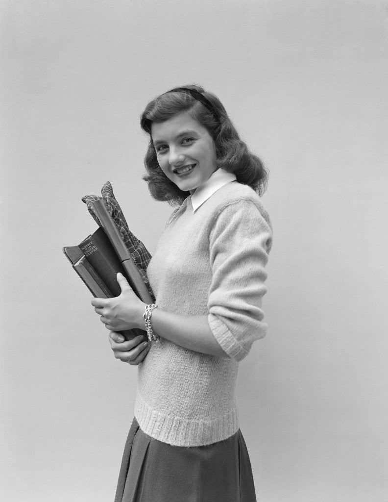Detail of Smiling brunette teen student wearing sweater carrying school books by Anonymous