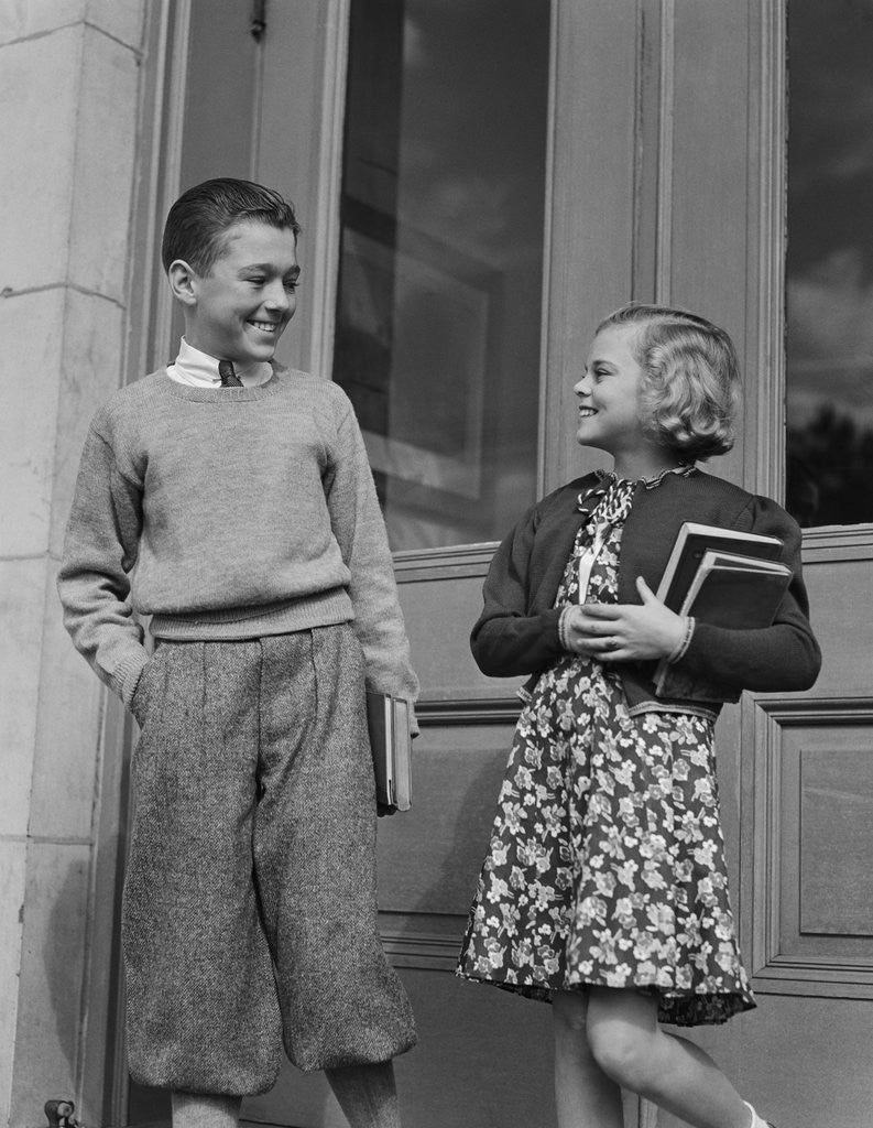 Detail of Smiling boy & girl holding school books by doors by Anonymous