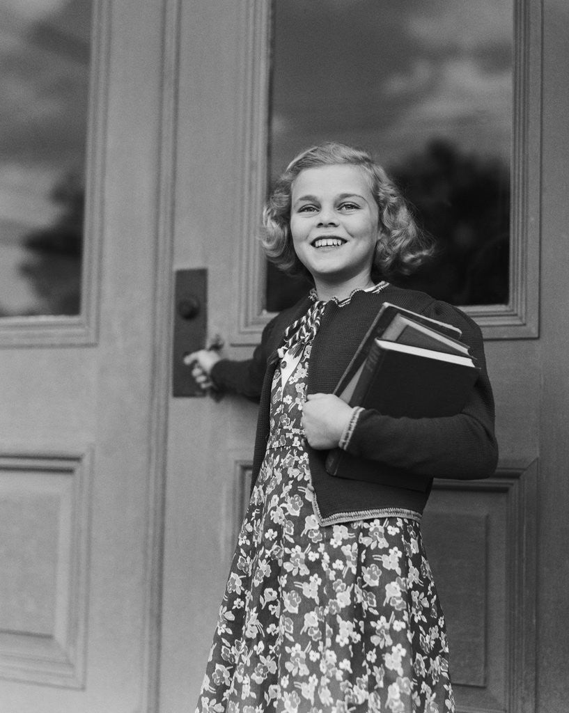 Detail of Smiling girl print dress holding school books opening door by Anonymous